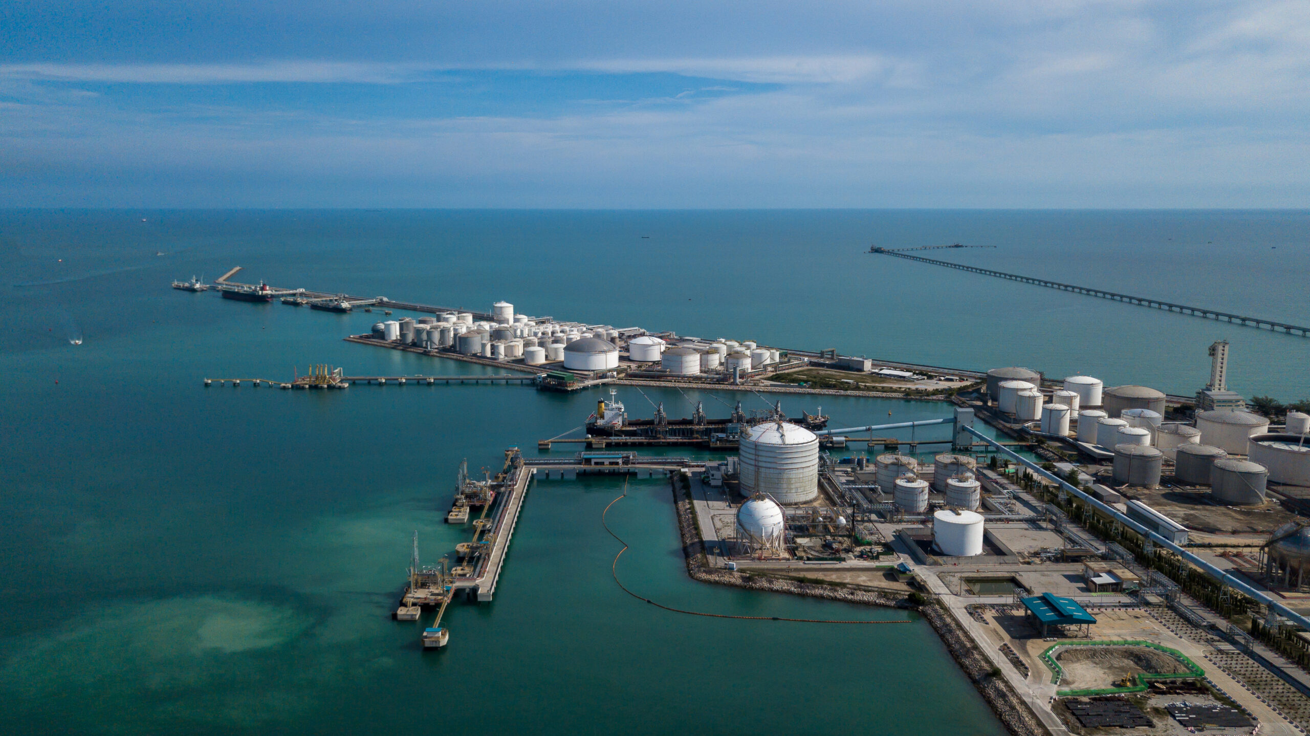 Aerial view oil tertminal storage tank, White oil tank storage chemical petroleum petrochemical refinery product at oil terminal, Business commercial trade fuel and energy transport by tanker ship vessel.